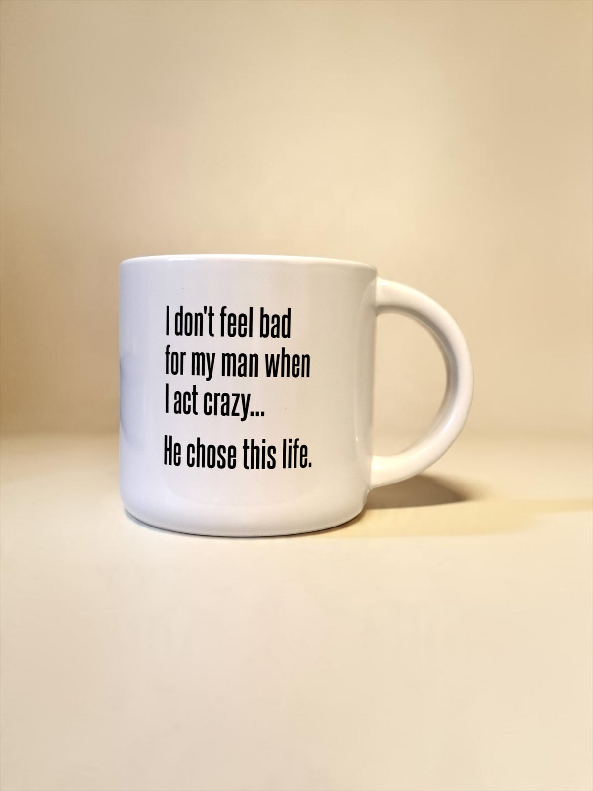 White ceramic coffee mug printed with “I don’t feel bad for my man when I act crazy... He chose this life.
