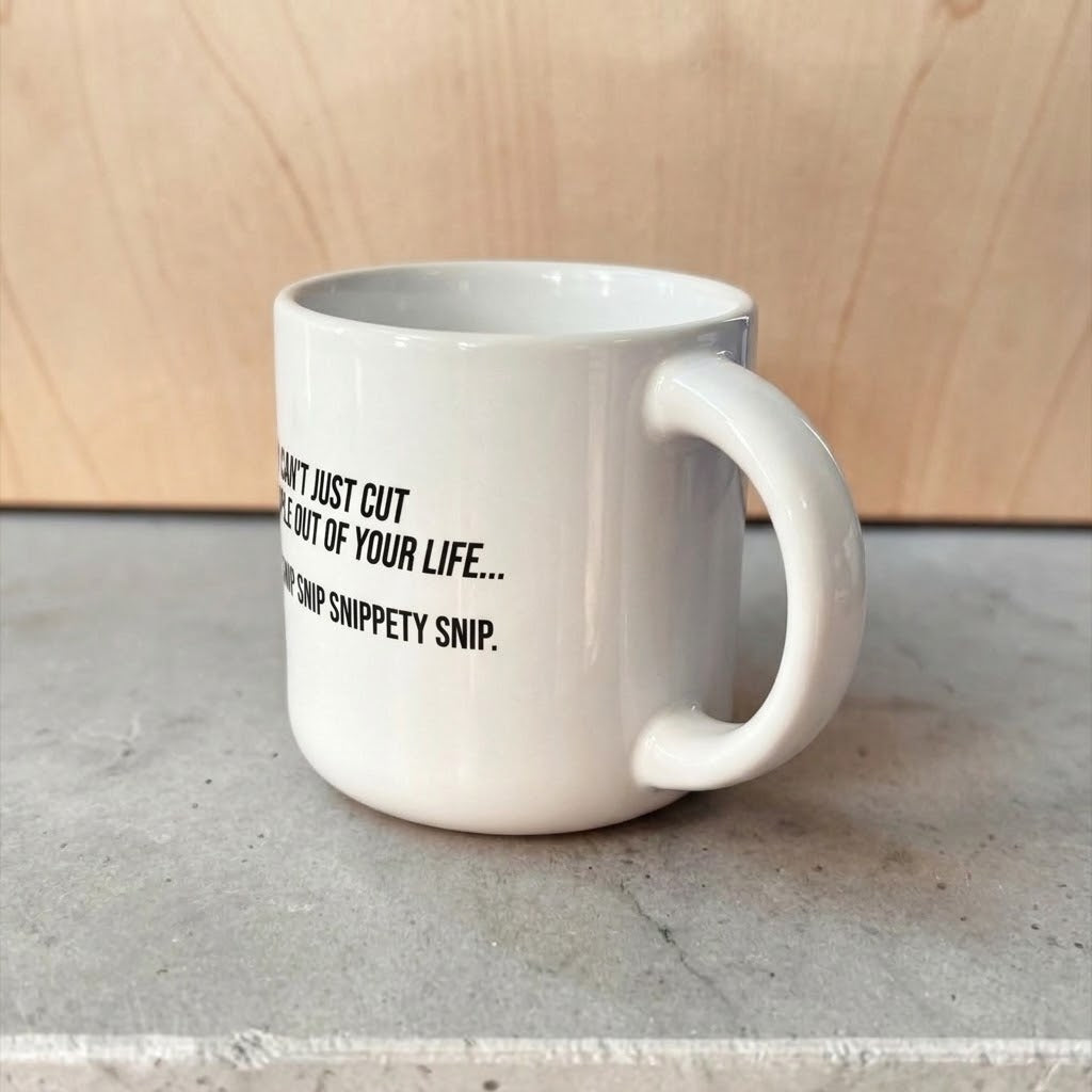 Coffee mug printed with “You can't just cut people out of your life. Snip snip.”, additional view