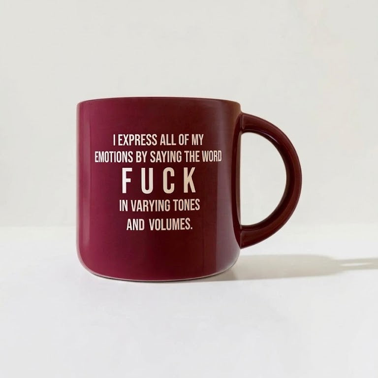 A dark red ceramic mug with white printed text that reads, 'I EXPRESS ALL OF MY EMOTIONS BY SAYING THE WORD FUCK IN VARYING TONES AND VOLUMES.' on a clean white background.